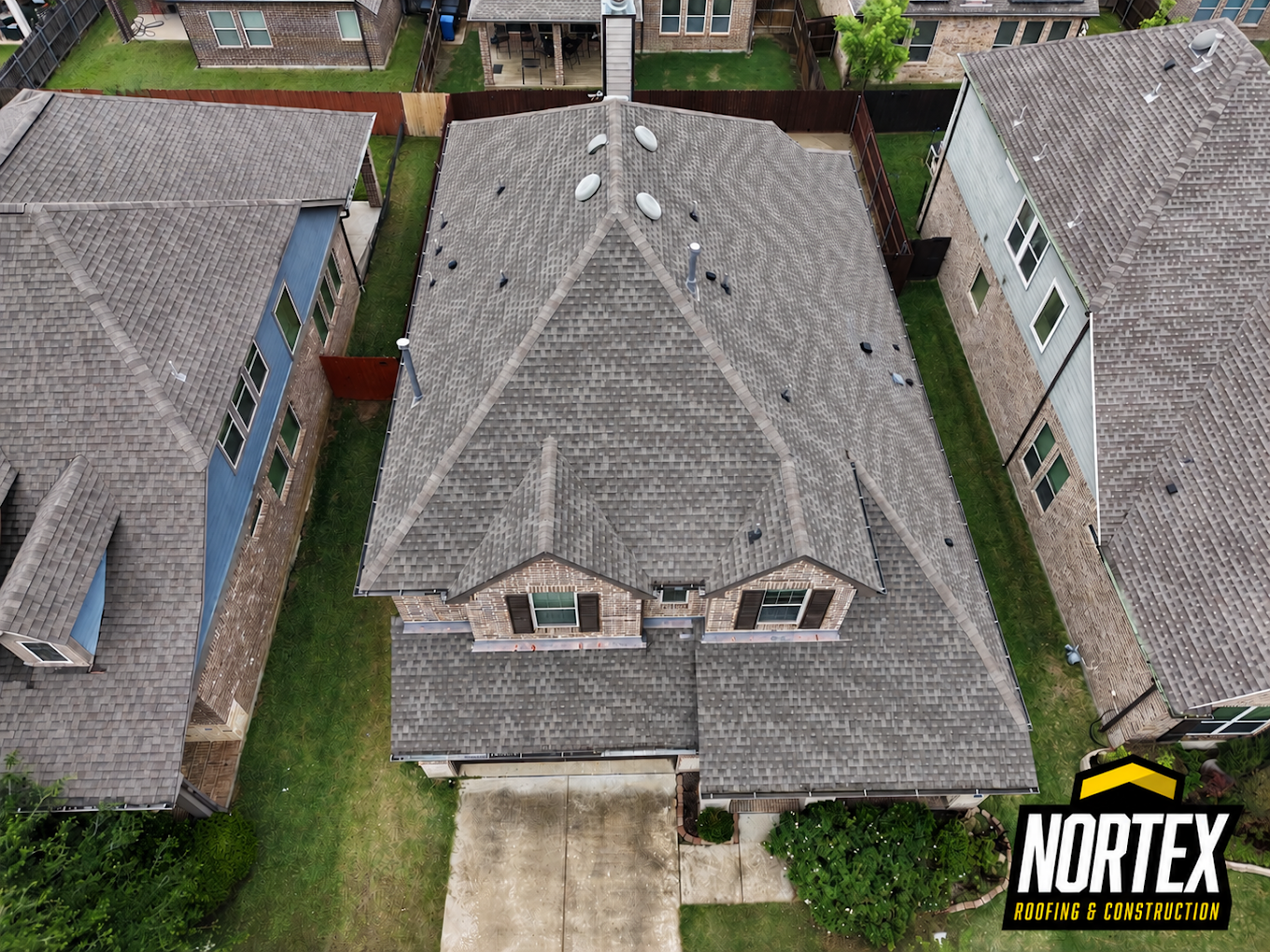 Aerial view of a completed architectural shingle roof replacement on a two-story home in Dallas, TX