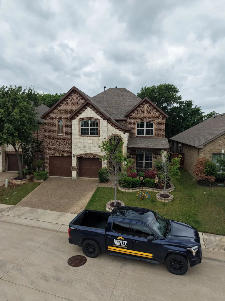 Nortex Roofing truck parked in front of a home in Des Moines, IA during a roof inspection